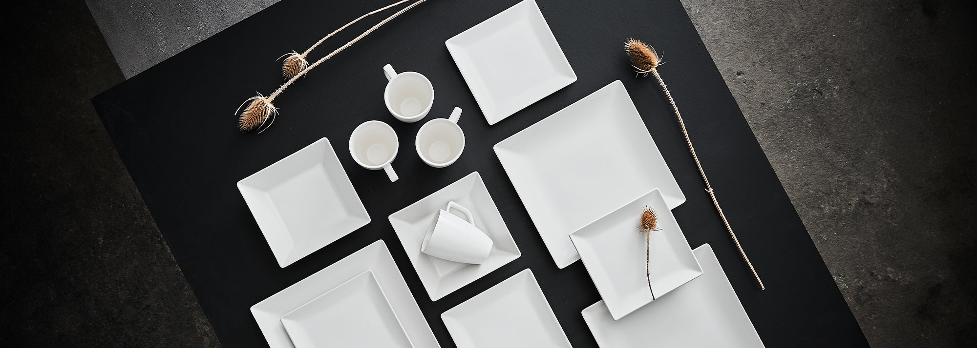 En stentøjsserie i farverne hvid og sort. Kvadratiske tallerkener i mange størrelser. Find også vendbare dækkeservietter.